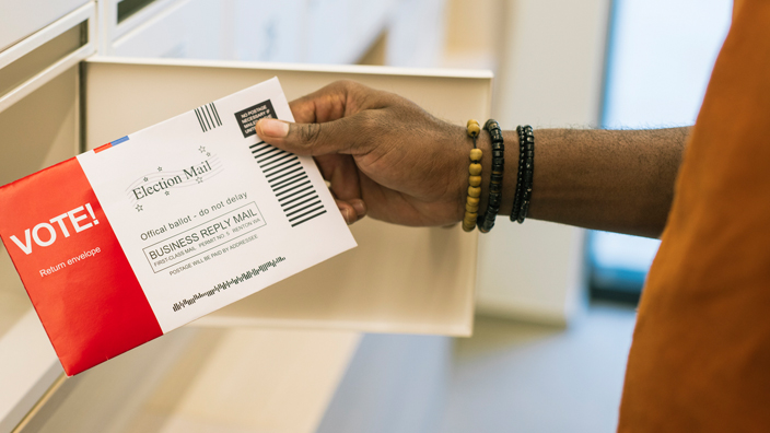 A customer holds an election mail official ballot
