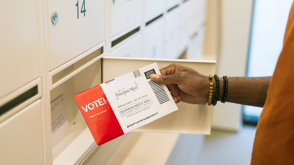 A customer holds an election mail official ballot