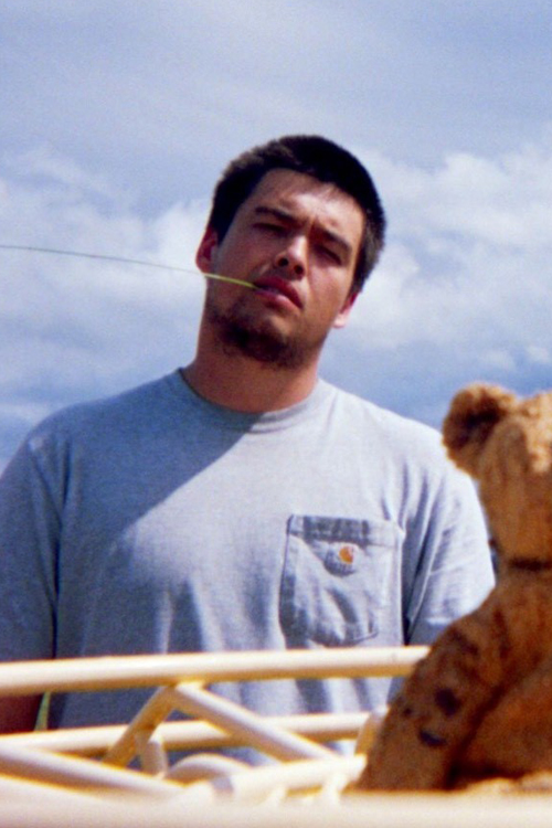 Young man in T-shirt stands outdoors