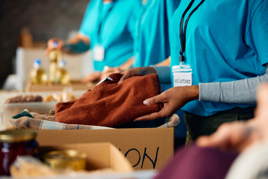 A volunteer places a reddish-orange sweater into a box