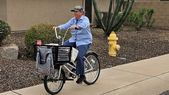 Kelly Fischer, a Sun City, AZ, letter carrier, rides a bike along her route.