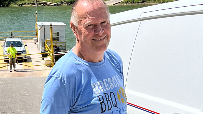 Larry Wilson, a Tompkinsville, KY, rural carrier, stands near the ferry he uses to help make his deliveries.