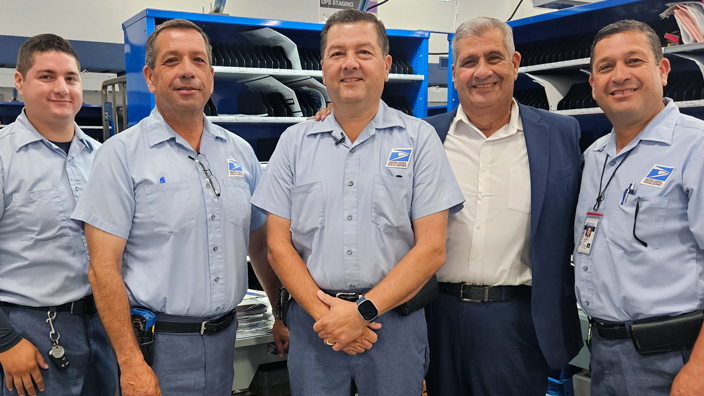 The Penas stand inside a workroom at the Chula Vista, CA, Post Office. From left are David J., Saul, David E., David F. and Helaman.