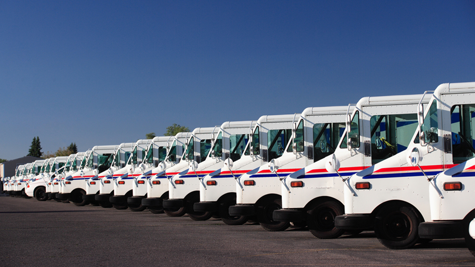 USPS-branded delivery vehicles parked in a row