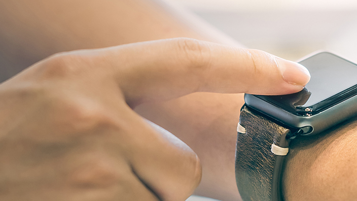 A user looks at a smartwatch