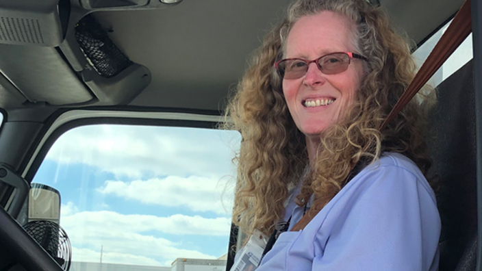 Beth Allen sits in the cab of the tractor trailer she operates out of Lexington, KY.