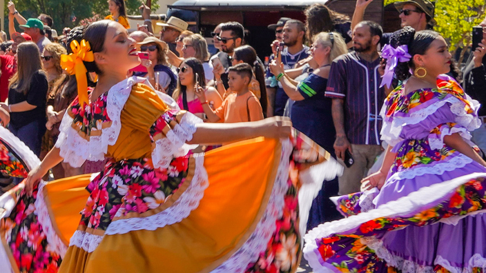 Women in colorful costumes dancing.