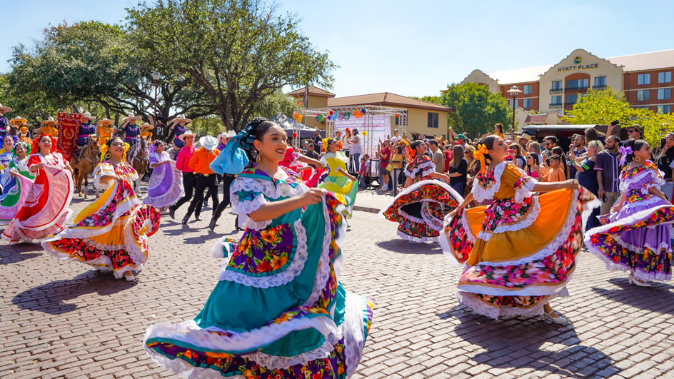 Women in colorful costumes dancing.