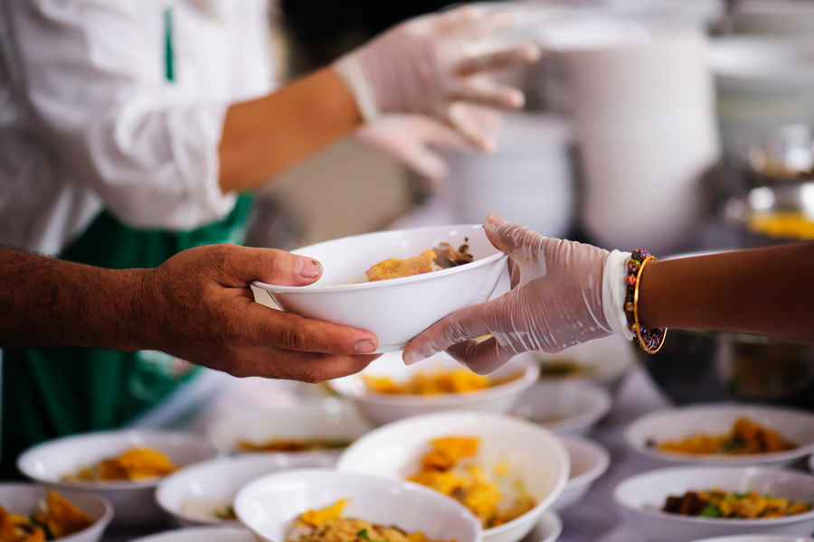 A volunteer handing out a bowl of food