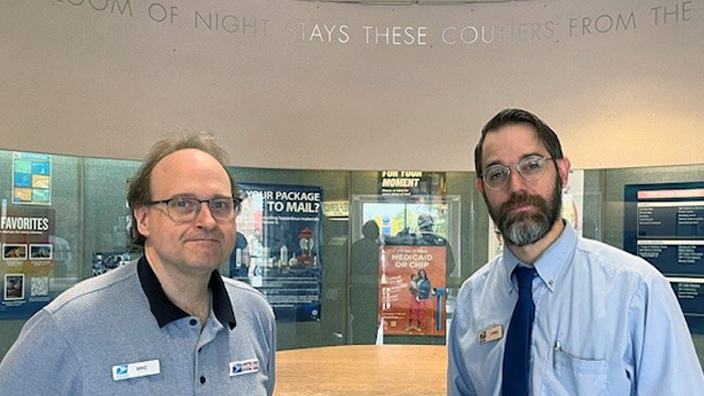 USPS retail associates Mike Bridges, left, and Chris Efta stand in the lobby at Mount Baker Station in Bellingham, WA.