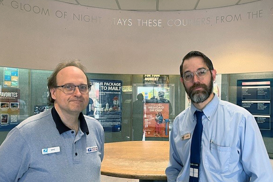 USPS retail associates Mike Bridges, left, and Chris Efta stand in the lobby at Mount Baker Station in Bellingham, WA.