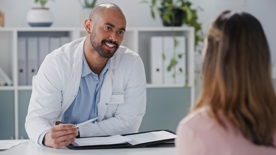 A male doctor talks with a female patient