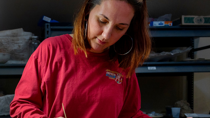 Theresa Smith, the Solomons, MD, postmaster, prepares a fossilized dolphin skull as part of her volunteer work on behalf of the Chesapeake Bay.