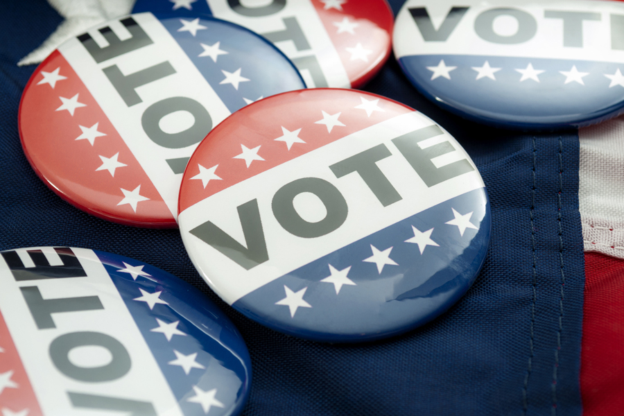 A display of buttons with patriotic colors that read "Vote"