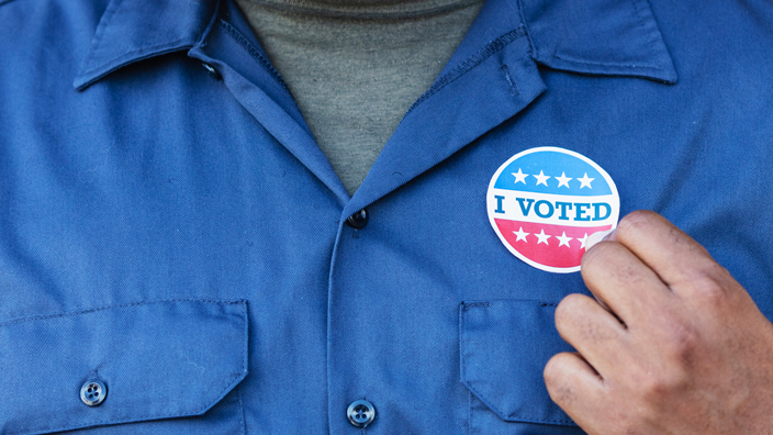 A man wearing an "I voted" sticker