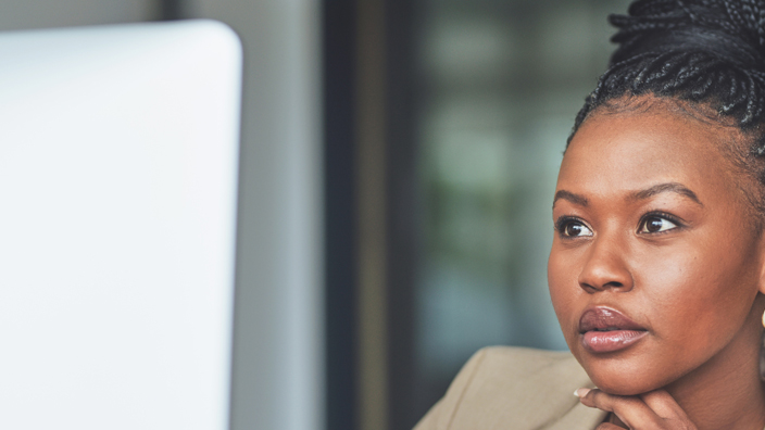 A woman looks at a computer monitor