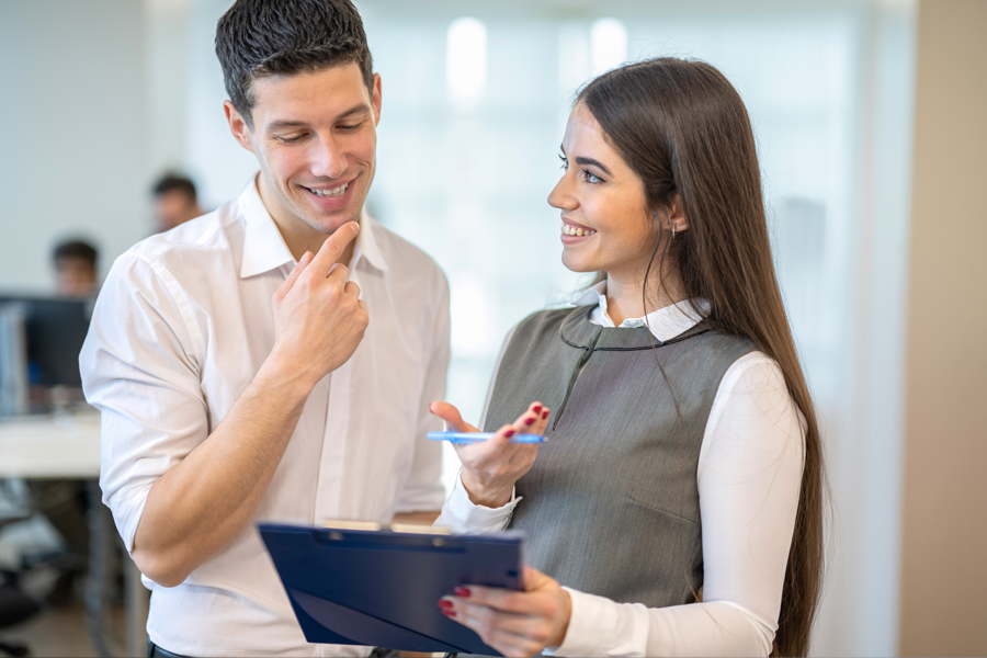 Two co-workers look a clipboard