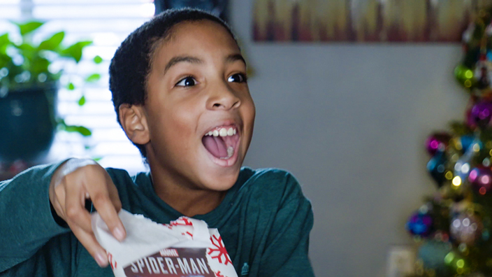 A child opens a Chrirsmas gift from the USPS Operation Santa program