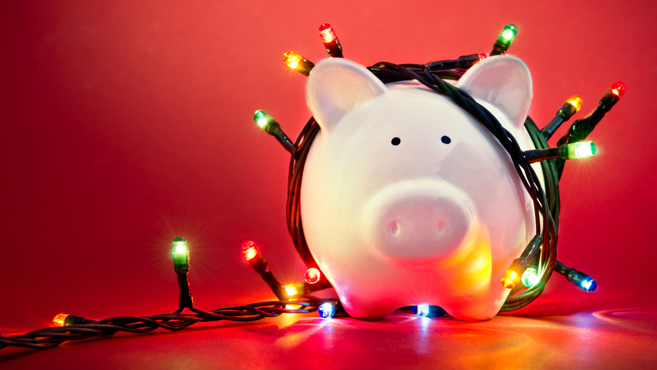 A piggybank wrapped in holiday lights