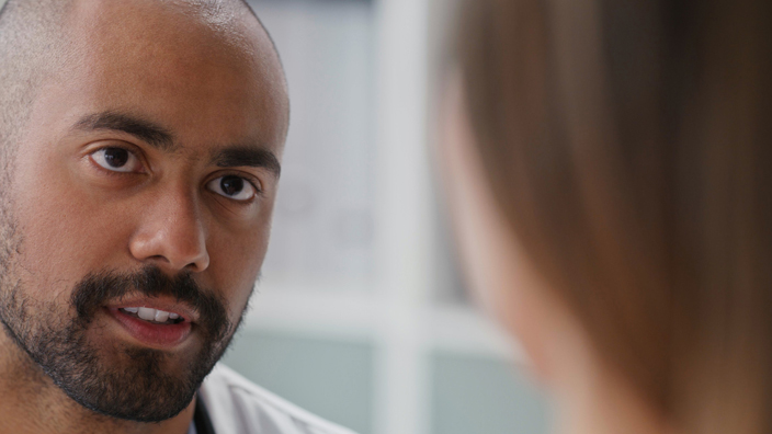 A male doctor talks with a female patient