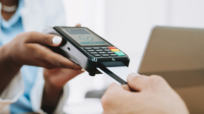 A person inserts a payment card into a card reader at a medical office.