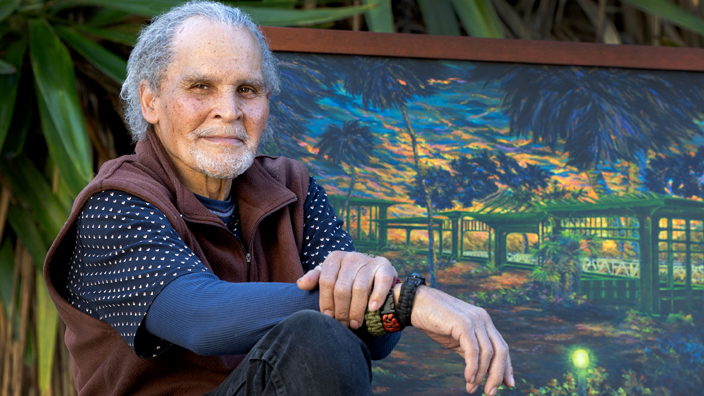 A man sitting in front of a painting.