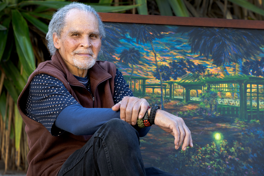 A man sitting in front of a painting.