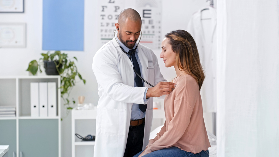 A doctor listening to a patient's heartbeat