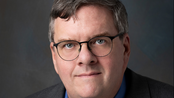 Studio portrait of a smiling man dressed in a business suit and tie