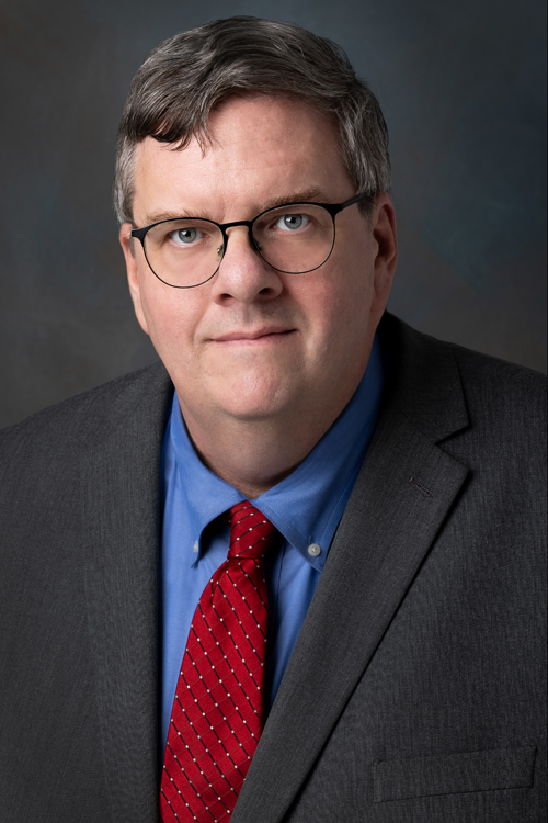 Studio portrait of a smiling man dressed in a business suit and tie