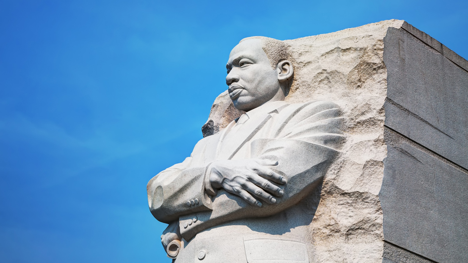 A close-up of a statue of Martin Luther King Jr. emerging from a mountainside