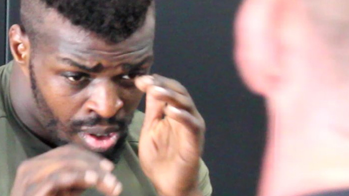 A tight close-up of a man sparring with another man in a gym