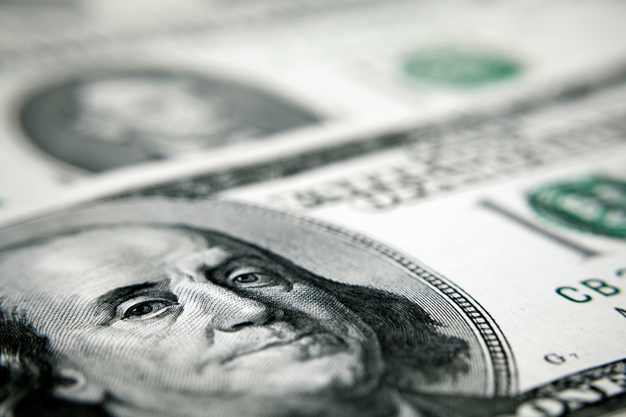 A close-up of a one hundred dollar bill in U.S. currency, with Benjamin Franklin’s portrait shown