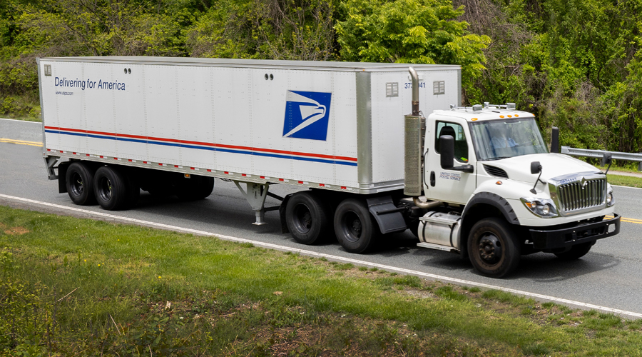 A USPS tractor-trailer moves down a highway