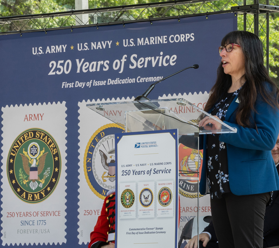 woman in a business suit speaks at a lectern
