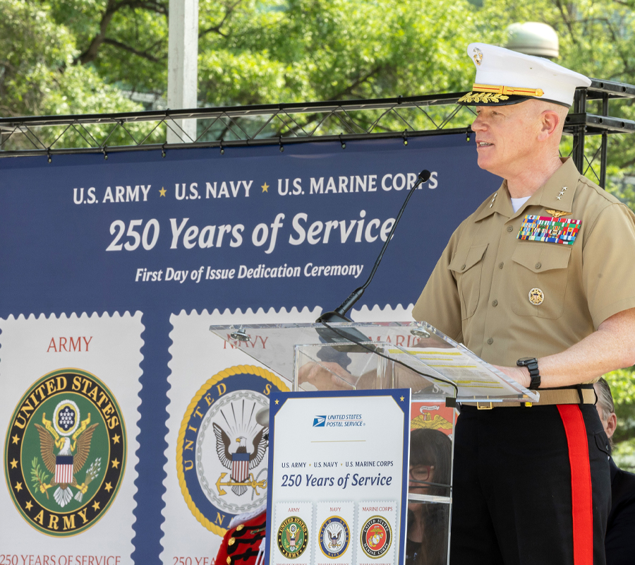 A man in a Marine Corps uniform speaks at a lectern
