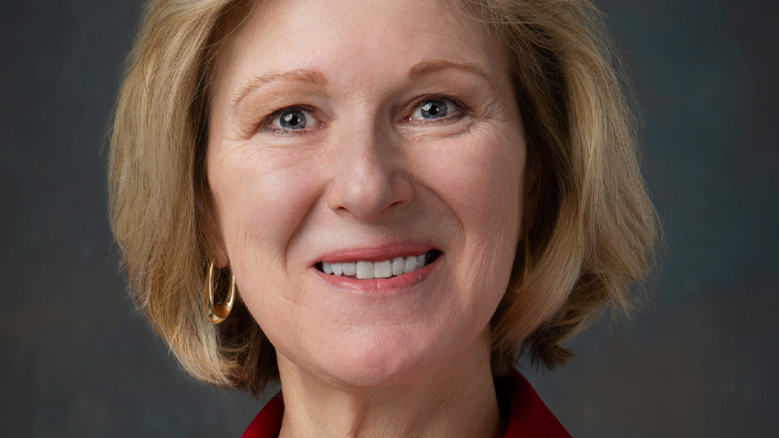 Studio portrait of a smiling woman wearing a business suit