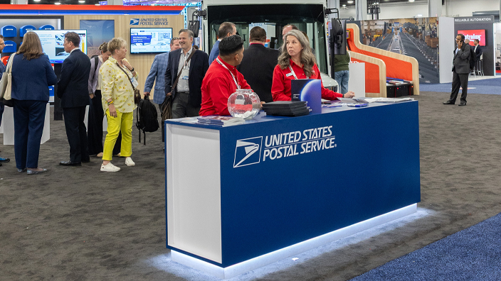 People mill around a conference center booth