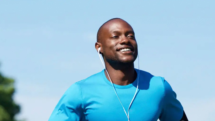 A man jogs outside in sunny weather