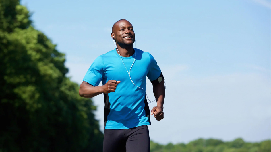 A man jogs outside in sunny weather