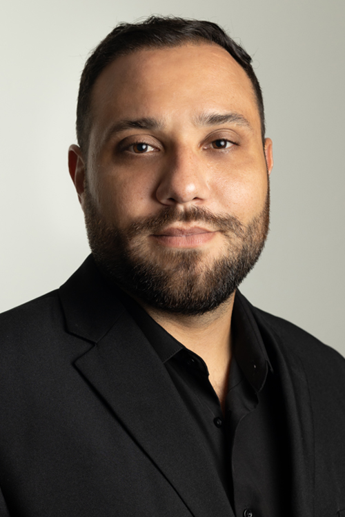 Studio portrait of a smiling man in a suit coat and open shirt