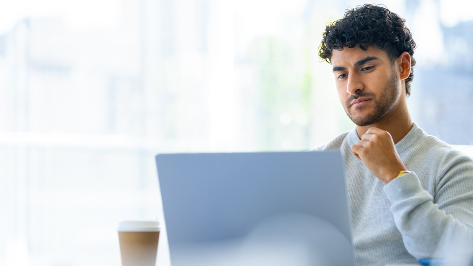 A man sits in front of a computer monitor in an office environment