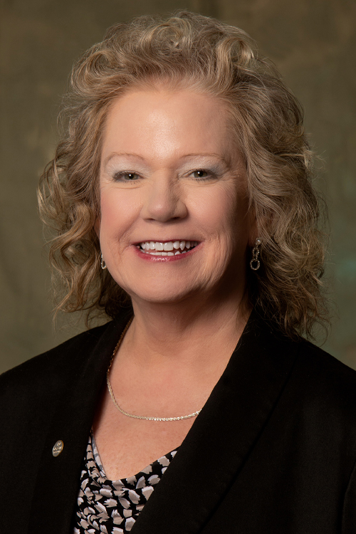 Studio portrait of a smiling woman wearing a business suit