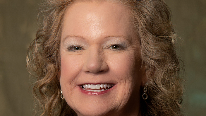Studio portrait of a smiling woman wearing a business suit