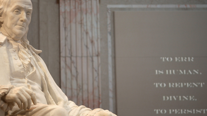 A white marble statue of Benjamin Franklin