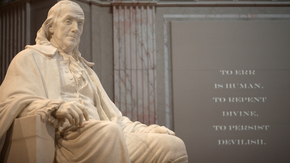A white marble statue of Benjamin Franklin