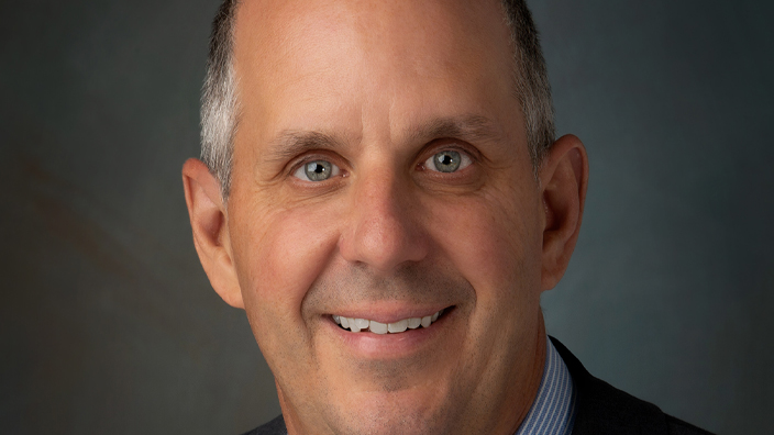 Studio portrait of a smiling man wearing a business suit