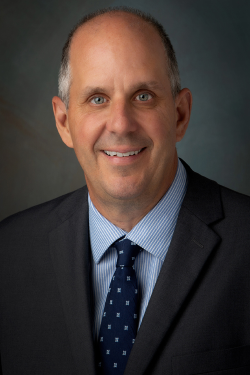 Studio portrait of a smiling man wearing a business suit