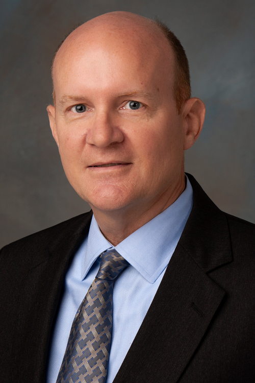 Studio portrait of a smiling man wearing a business suit