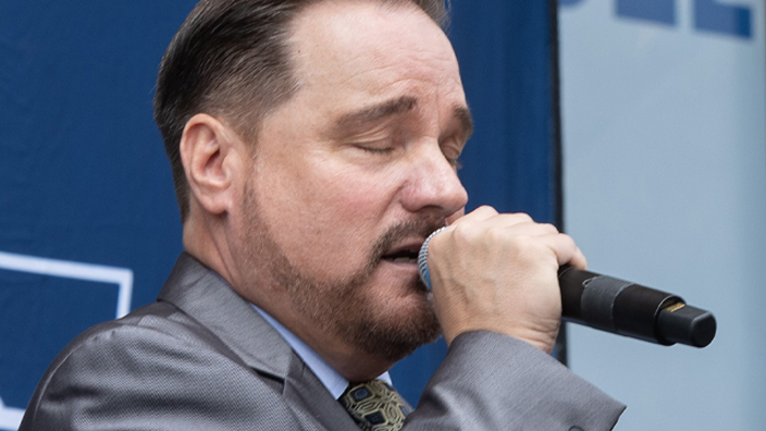A man sings into a microphone